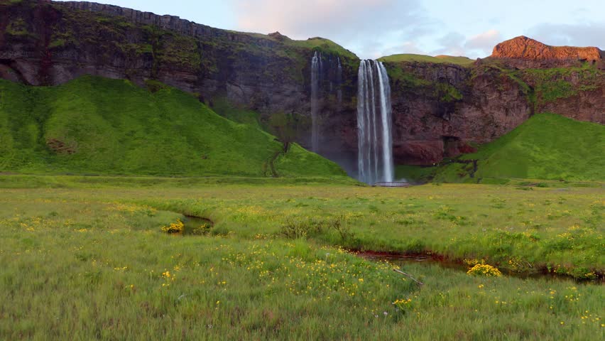 4k drone forward video (Ultra High Definition) of Seljalandsfoss waterfall. Colorful sunrise in Iceland, Europe. Beauty of nature concept background. Royalty-Free Stock Footage #3394385613