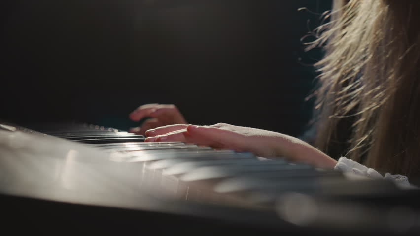 Piano keys feel touch of girl fingers. Gifted girl delves into intricacies of melody during musical lesson in audio studio. Musical talent of children Royalty-Free Stock Footage #3394453099