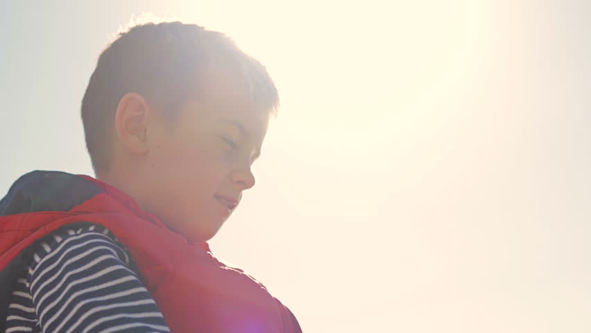 Boy looks high in the sky. Closeup.