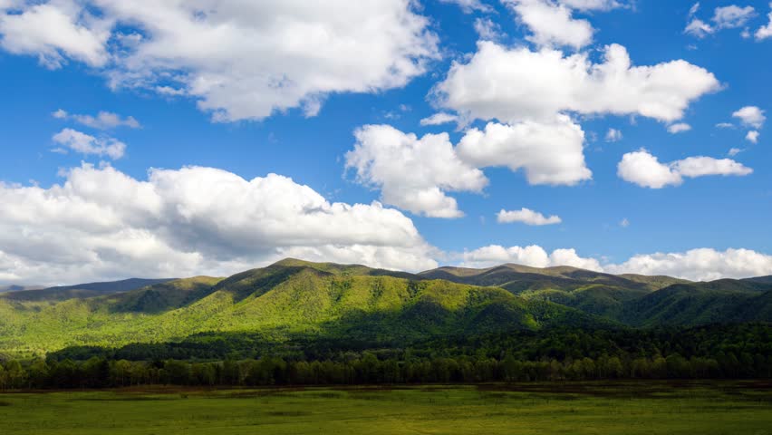 Witness the breathtaking beauty of clouds gracefully gliding over the magnificent Great Smoky Mountains in Cades Cove. 
 Royalty-Free Stock Footage #3394624019