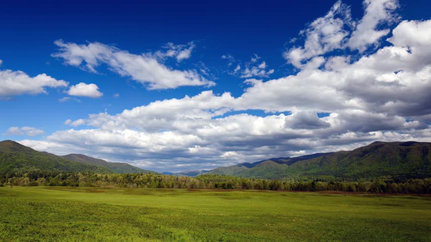 Witness the breathtaking beauty of clouds gracefully gliding over the magnificent Great Smoky Mountains in Cades Cove. 
 Royalty-Free Stock Footage #3394625711