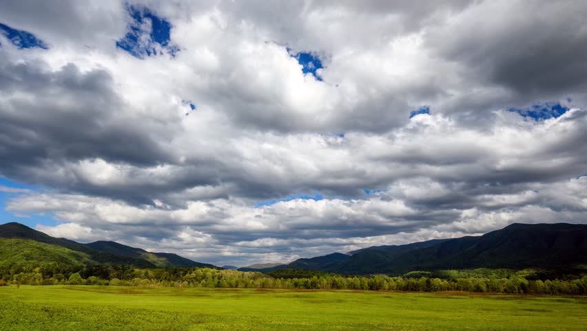Witness the breathtaking beauty of clouds gracefully gliding over the magnificent Great Smoky Mountains in Cades Cove. 
 Royalty-Free Stock Footage #3394626381