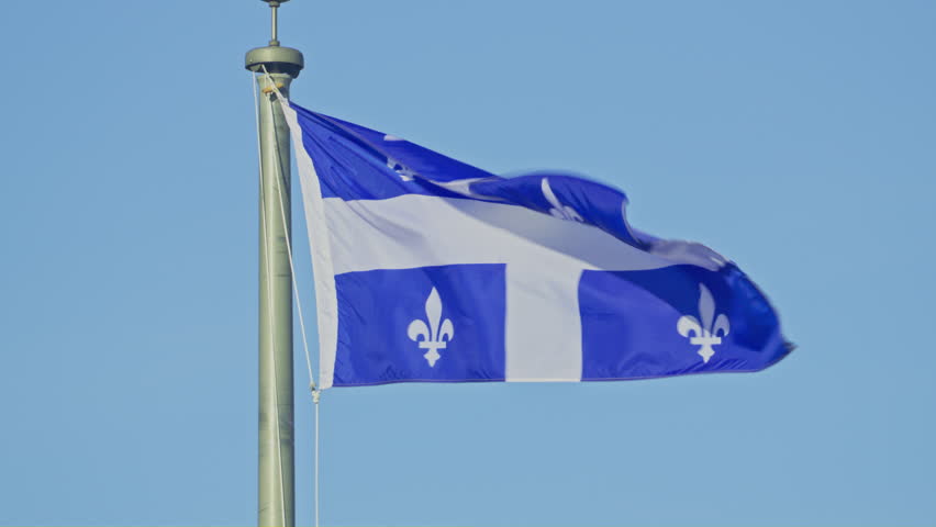 Quebec province flag in wind blue sky