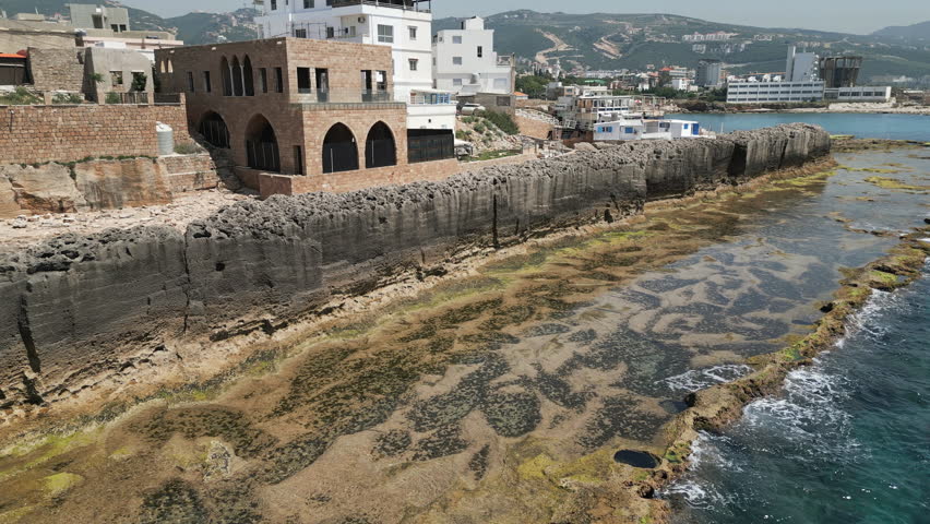 Ancient Phoenician wall, a protective stone structure situated on the Mediterranean seafront in Batroun, Lebanon. Drone footage.