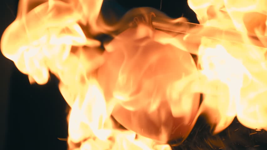 A balloon, inflated with flammable gas, bursts and forms a large fireball on black background. Closeup. Slow mo, slo mo, slow motion, high speed camera, 240fps, 250fps