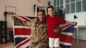 Soldier father and little boy wrapped in United Kingdom flag, patriotic symbol - Powered by Shutterstock - Get 15% off with code: PIKWIZARD15