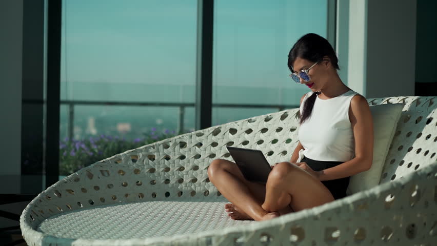 Young Asian business woman wear suit sit on couch chair working on laptop in modern modern business lounge office. Gorgeous lady freelancer digital nomad concept. Working online. Urban background Royalty-Free Stock Footage #3394803849