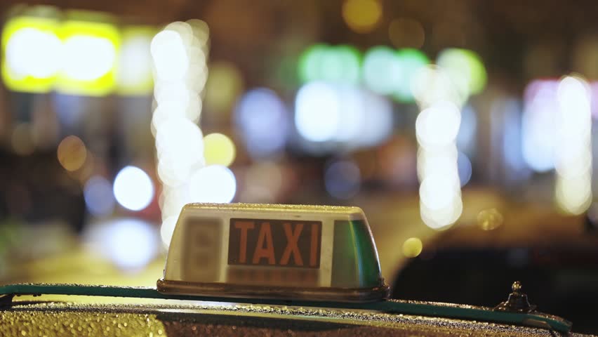 A Taxi Sign on a Car - busy night street Royalty-Free Stock Footage #3394811437