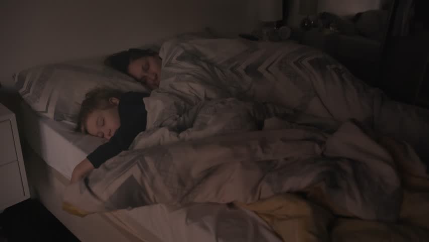 A mom and three years old little son is sleeping in the bed Royalty-Free Stock Footage #3394825393