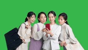 A group of Asian women talking while looking at their smartphones.  Green background for chroma key composition.
