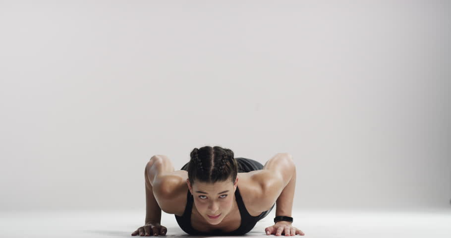 Fitness, arms and pushup with a young woman in studio on a white background for a health workout. Portrait, exercise and strong with a confident athlete training her muscles closeup at the gym Royalty-Free Stock Footage #3395088901