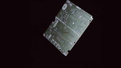Printed circuit board flies and rotates on a black background. Closeup. Slow mo, slo mo, slow motion, high speed camera, 240 fps, 250 fps