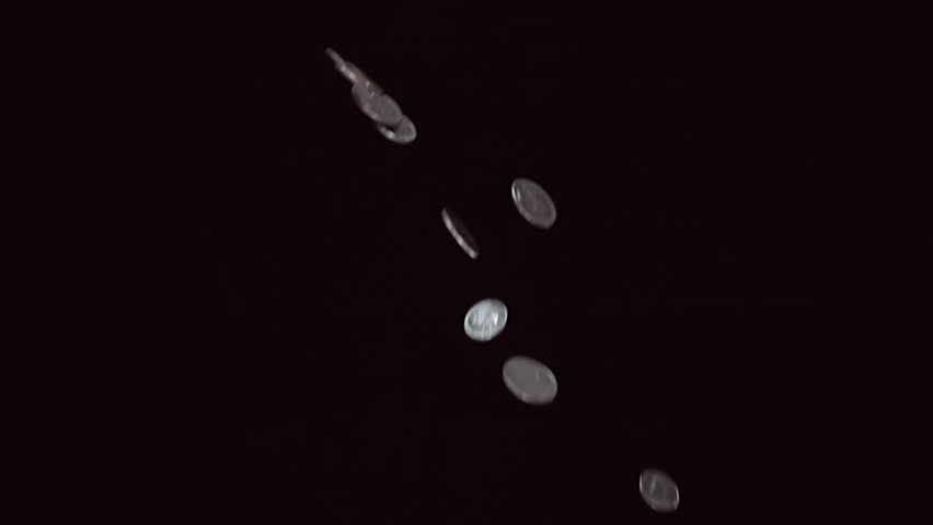 Metal coins flies and rotates on a black background. Close Up. Slow mo, slo mo, slow motion, high speed camera, 240fps, 250fps