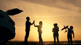 Happy family concept. family travel by car. weekend with family in nature. Children and parents play clapping at sunset and launch a toy plane next to the car. kid running with toy airplane at sunset - Powered by Shutterstock - Get 15% off with code: PIKWIZARD15