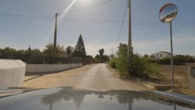 First person view, FPV, from dashcam of car driving towards the Benagil Caves, Algarve Coast, Portugal. Road trip video in POV, with blue sky on a bright sunny day, driving on narrow roads