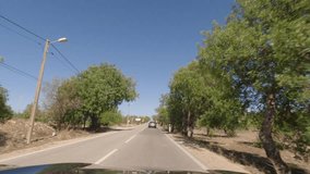 First person view, FPV, from dashcam of car driving along the Algarve Coast in Portugal, driving on the highway towards Faro. Road trip video in POV, with blue sky