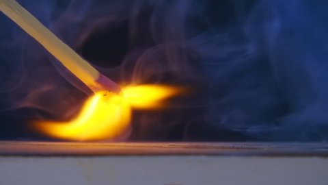 The match in the hand moves on the side of the matchbox and light the fire. S-log - High Dynamic Range. Macro. Closeup. Shallow depth of field. Slow mo, slo mo, slow motion, high speed camera, 240fps,