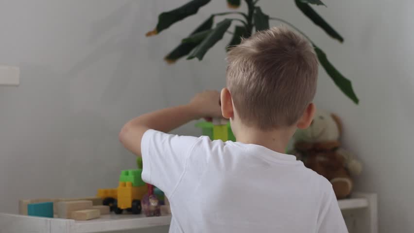 a boy plays with a multi-colored construction set in the form of geometric shapes in a bright room - Powered by Shutterstock - Get 15% off with code: PIKWIZARD15