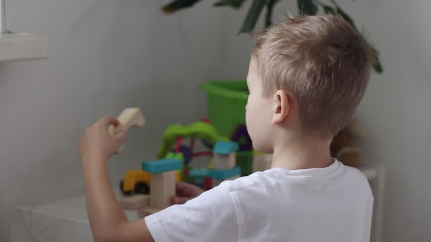 a boy plays with a multi-colored construction set in the form of geometric shapes in a bright room - Powered by Shutterstock - Get 15% off with code: PIKWIZARD15