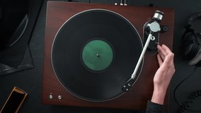 Turning on a Turntable: Placing Vinyl on the Platter, Spinning, and Lowering the Tonearm onto the Record - Table Top View, Slow Motion, Dolly out - Powered by Shutterstock - Get 15% off with code: PIKWIZARD15