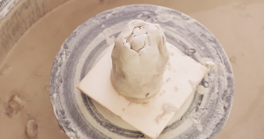 Man, hands and pottery on wheel for art, craft and sculpture with clay for production, manufacturing and textile expert. Unique design, professional mud mould and creative process for earth ware bowl