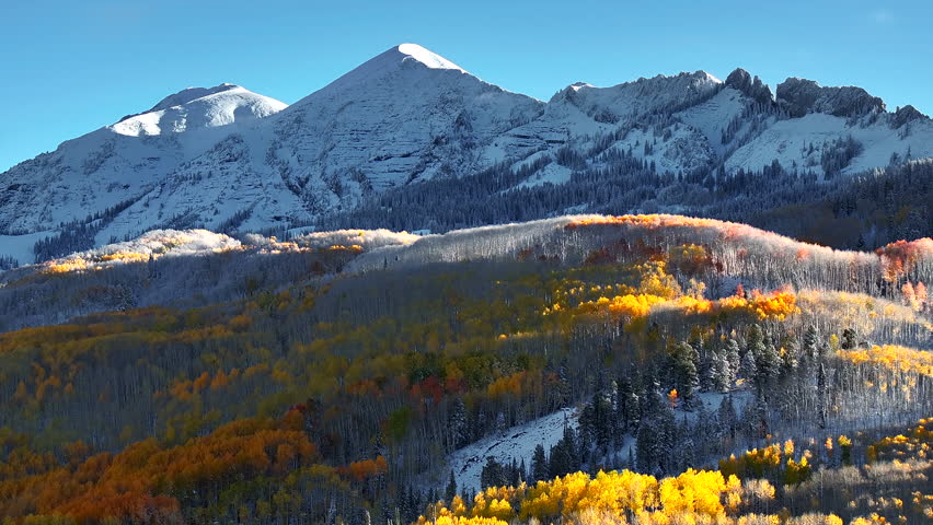 Kebler Pass aerial cinematic drone Crested Butte Gunnison Colorado seasons crash early fall aspen tree red yellow orange forest winter first snow powder Rocky Mountain peaks backward motion