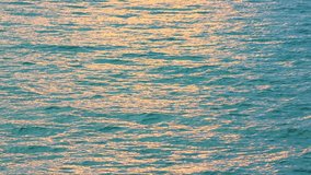 Sunset sunrise light in sea water surface.Sunrays flickering in ocean shimmering sea waves in sun Abstract background,Amazing autumn and summer background,seamless loop nature video background