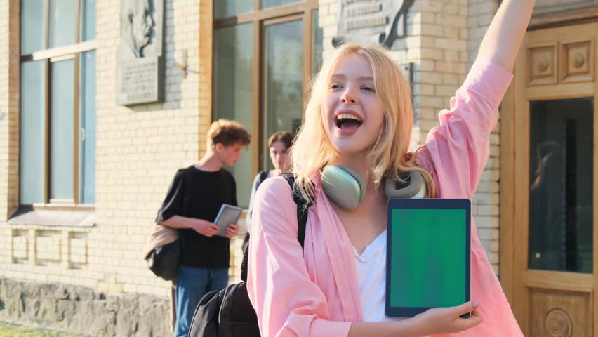 Happy student girl with blond hair waves to friend as sign of friendly greeting. Chance meeting with old childhood friend in adolescence