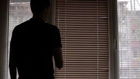 Man closing the blinds or curtains on the window. Solar light through closed blinds. - Powered by Shutterstock - Get 15% off with code: PIKWIZARD15