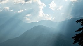 4K timelapse of Himalaya mountains with sun god rays shining through clouds in Manali, Himachal Pradesh, India. Time lapse of clouds moving over mountains. Dramatic sunrays through the clouds - Powered by Shutterstock - Get 15% off with code: PIKWIZARD15