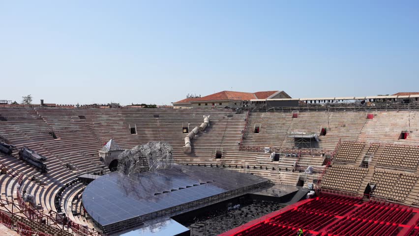 Stage and red carpet with seats in Arena di Verona ready for an opera. Tilt down Royalty-Free Stock Footage #3395397915
