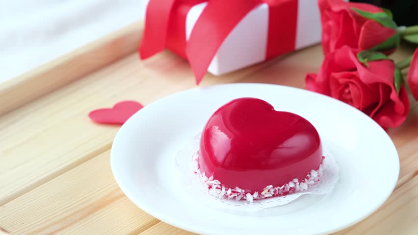 Valentines day. heart shaped glazed valentine cake and coffee in wooden tray
