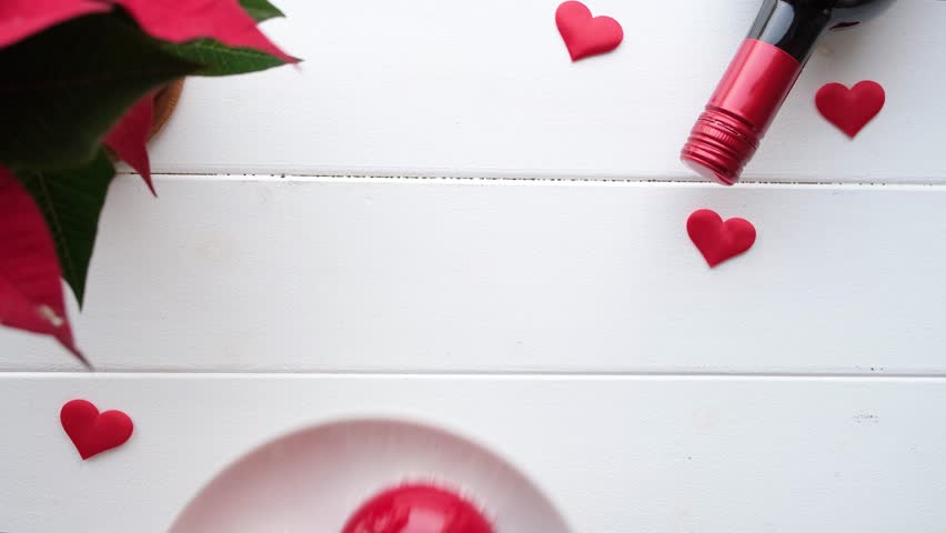 Valentines day. heart shaped confetti falling on white wooden table decorated for valentines day