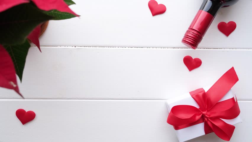 Valentines day. heart shaped confetti falling on white wooden table decorated for valentines day