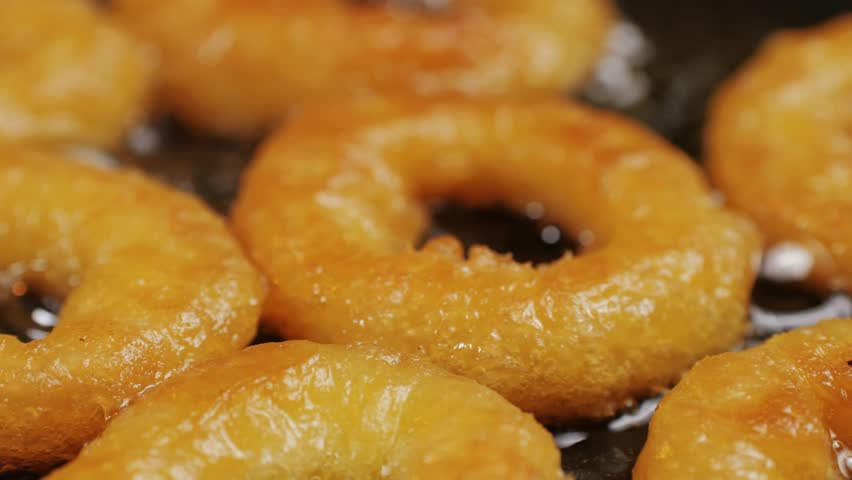 Fried crispy onion rings in a frying pan with oil close-up macro. Roasted onion rings for snacks at bar, cafe. Fast food. Delivery. Beer snacks