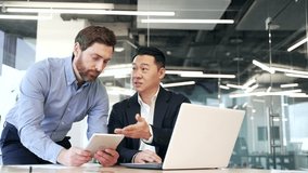 Business men discussing financial market data using laptop and digital tablet. Two diverse employees communicate Financial advisor broker manager consult investor client investment at office meeting - Powered by Shutterstock - Get 15% off with code: PIKWIZARD15