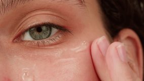 Young woman applying hydrogelic serum cream on her face close-up. Morning skin care routine. Pink background - Powered by Shutterstock - Get 15% off with code: PIKWIZARD15