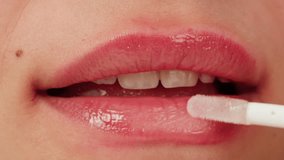 Beauty lip care. Young woman applying hygienic lipstick on lips close-up on pink background. Make-up routine - Powered by Shutterstock - Get 15% off with code: PIKWIZARD15