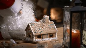 Santa Claus decorating a gingerbread house with sweet patterns in his residence with a fireplace and a Christmas tree - Powered by Shutterstock - Get 15% off with code: PIKWIZARD15