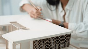 Closeup of professional engineer architect using triangular scale measure house model with focusing, taking note about building structure length at modern office. Business design. Immaculate. - Powered by Shutterstock - Get 15% off with code: PIKWIZARD15