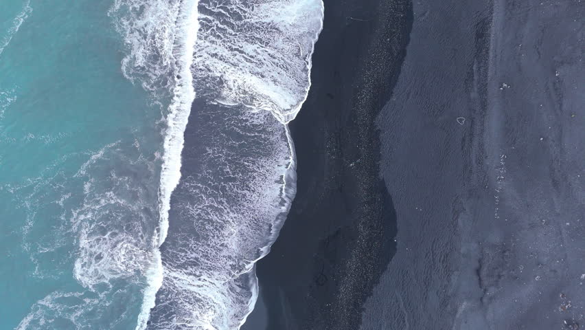 Aerial view of gentle white foaming waves fading smoothly on icelandic black sand beach, beautiful combination of land and water space, tourist attraction. High quality 4k footage Royalty-Free Stock Footage #3395526827