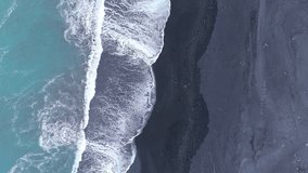 Aerial view of gentle white foaming waves fading smoothly on icelandic black sand beach, beautiful combination of land and water space, tourist attraction. High quality 4k footage