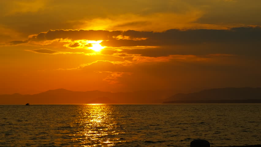 Alone bay silhouette against nightfall. A view of colorful sky over the lake during nightfall time.