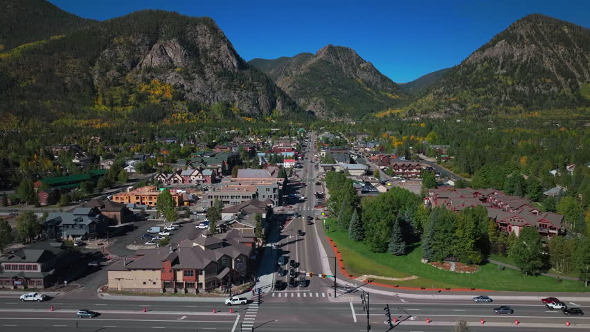 Downtown Frisco Colorado aerial cinematic drone traffic Main Street early yellow fall colors Aspen trees morning Lake Dillon Keystone Breckenridge Silverthorne Ten Mile Range blue sky upward motion