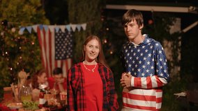 Close-up. A guy hugs a girl on Independence Day at a picnic with friends. - Powered by Shutterstock - Get 15% off with code: PIKWIZARD15