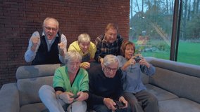 group of senior friends people playing video games at home