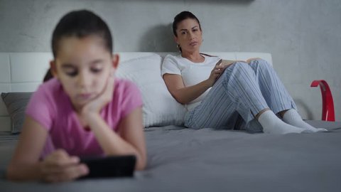 Dangers of Technology and Internet for Young People. Little Girl Spends Too Much time on Mobile Phone. Mother Reading Worries. Daughter Disconnected.