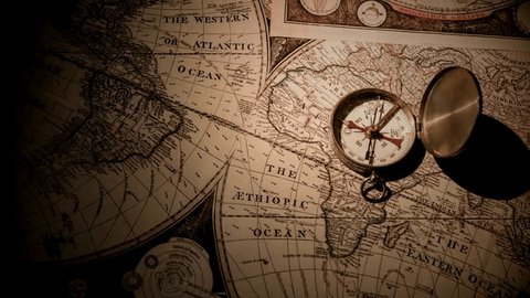 Old vintage retro compass on ancient map background. Antique bronze emblem compass on ancient world map. Travel geography navigation concept background. Old compass over ancient map. स्टॉक व्हिडिओ