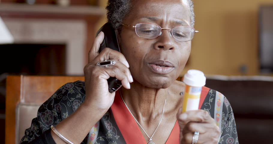 Cheerful African American senior woman finishing refilling her prescription or conversation with her doctor or health care provider.
