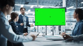 Electronics Factory Office Meeting: Caucasian Male CEO Presenting Innovative High-Tech Device On TV With Green Screen Chromakey. Diverse Engineers And Technicians Listening, Planning Production. - Powered by Shutterstock - Get 15% off with code: PIKWIZARD15